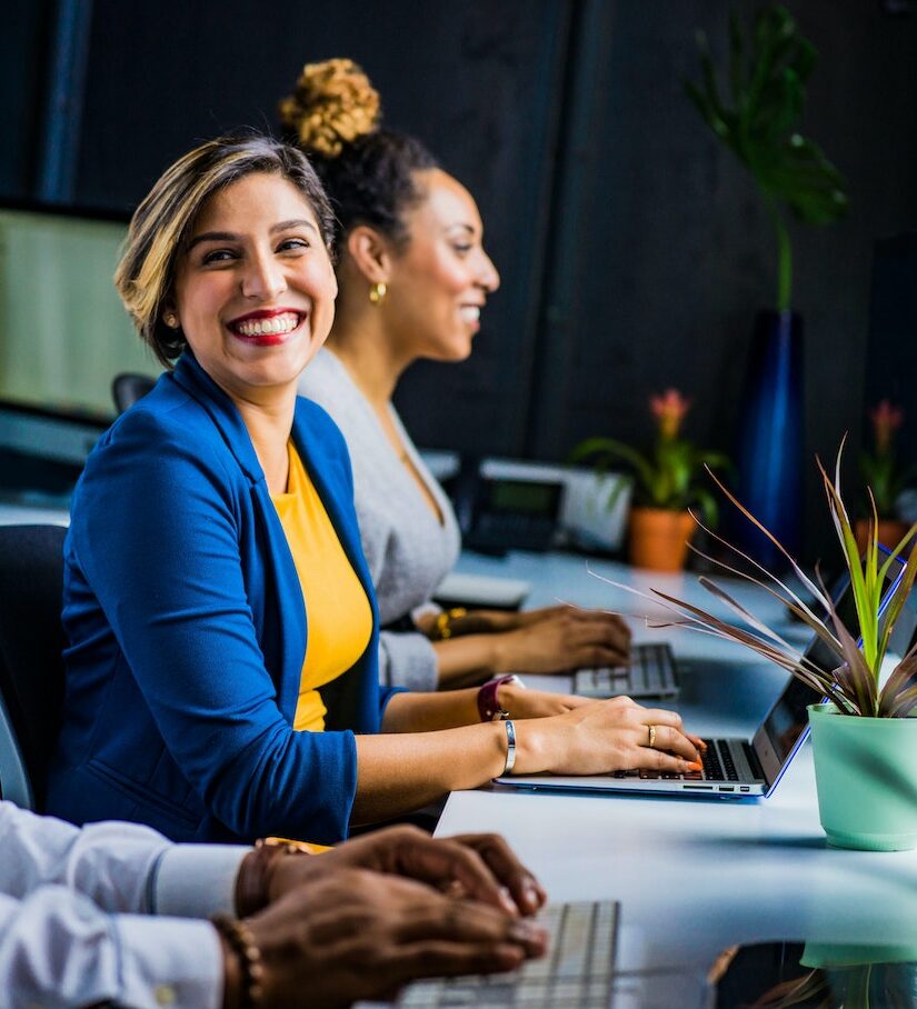 smiling woman in blue jacket behind computer. IT services